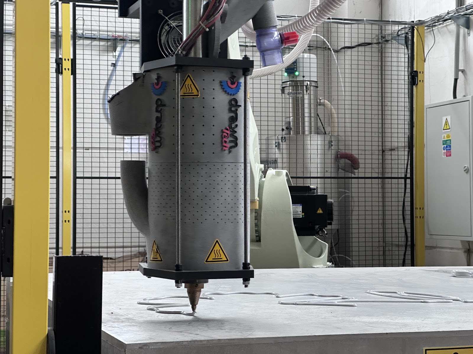 Detail tiskové hlavy průmyslového stroje v dílně při zpracování materiálu pro výrobu prvků světelné dekorace.